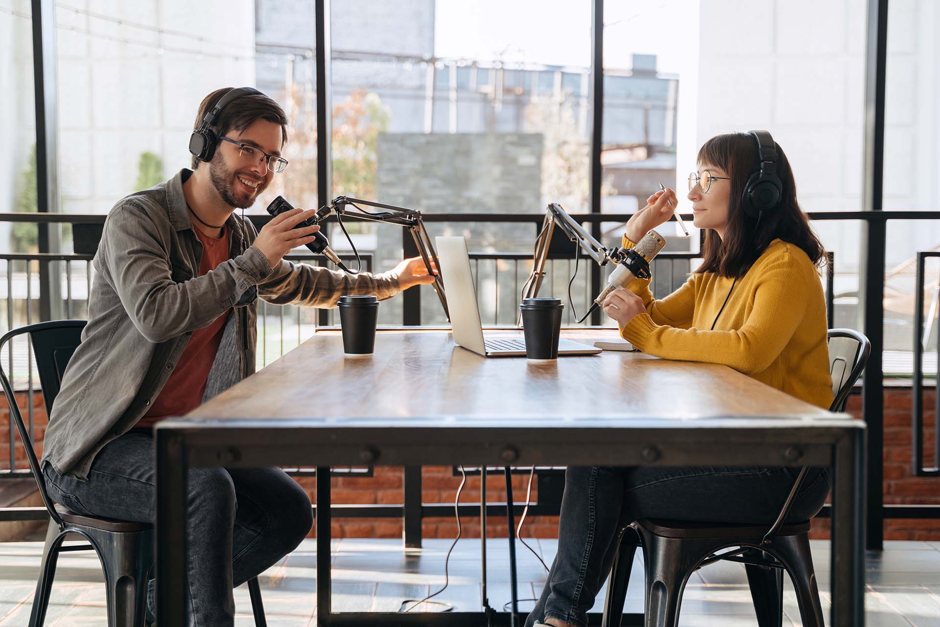Side view of man and woman broadcasting audio podcast